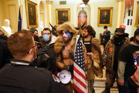 Members of the Proud Boys, one group among the hundreds of Trump supporters who violently stormed the U.S. Capitol in Washington on January 6, stand before police officers.