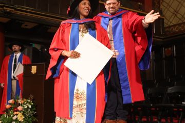 Hiwot Mekuanent receives her PhD in Law degree as she crosses the stage in Grant Hall at the Fall 2024 Convocation ceremony on Nov. 15. (Photo by Bernard Clark)